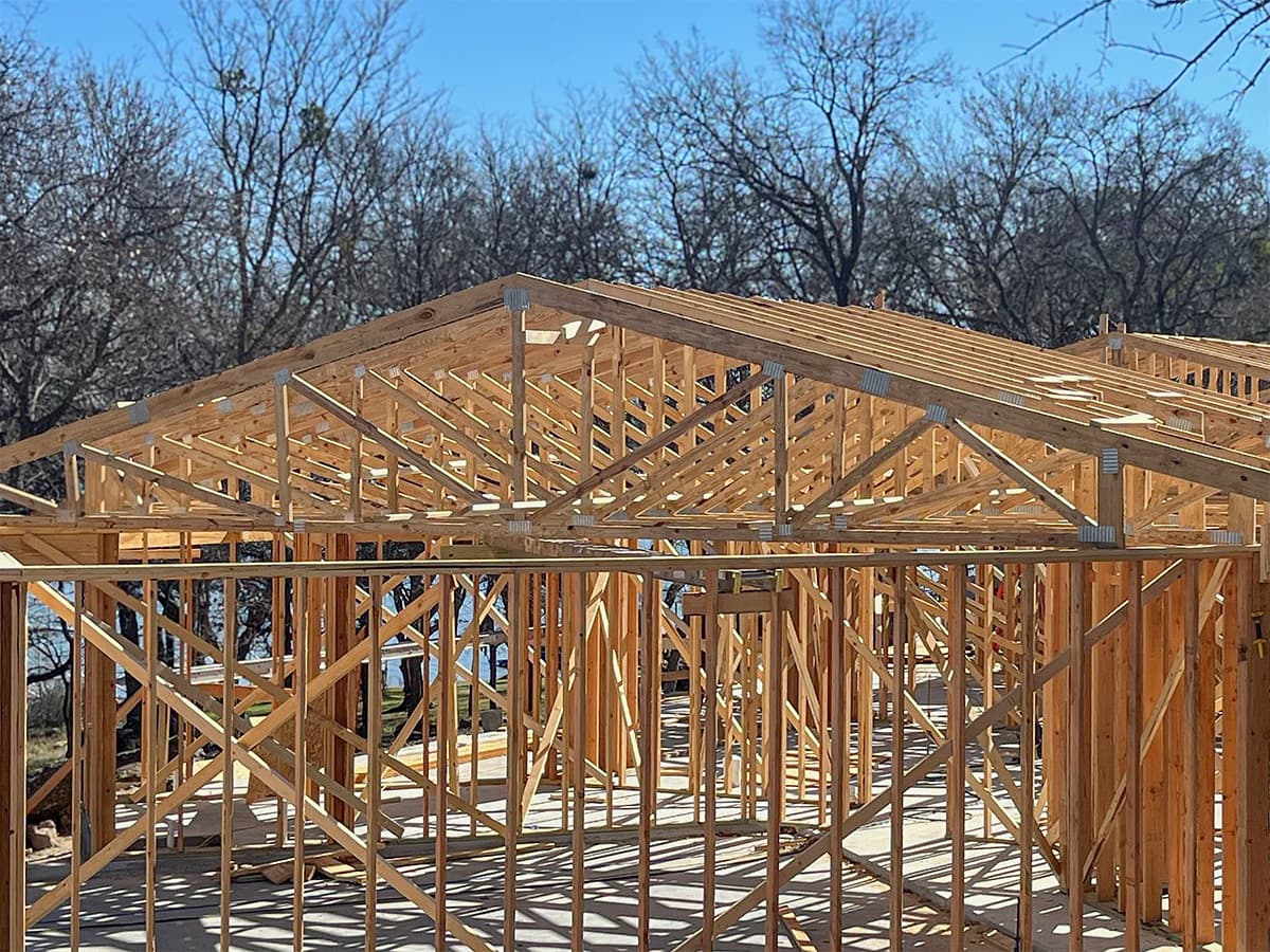 Framing stage of lakehouse project with roof trusses installed