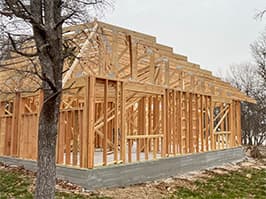 Framing stage of lakehouse project with roof trusses installed