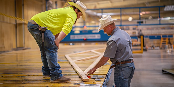 Two employees discussing a roof truss project